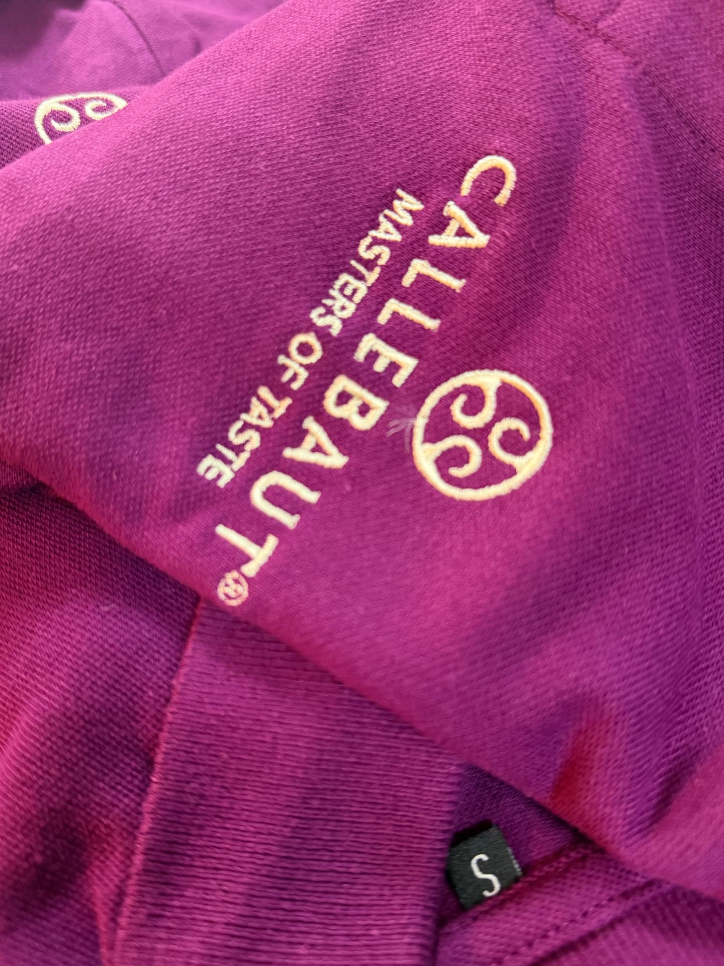 Cream embroidery stitched onto a burgundy hoodie